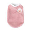 A soft pink knitted pet vest with a white embroidered face detail.