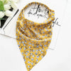 A yellow bohemian paisley triangle scarf draped on a white background.