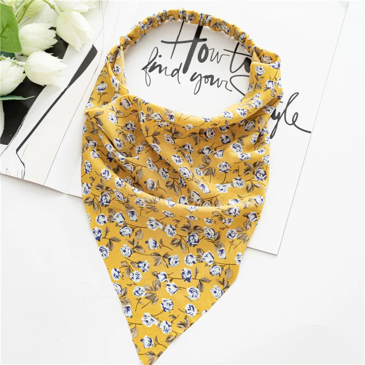 A yellow bohemian paisley triangle scarf draped on a white background.