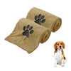 A tan microfiber dog towel with a black embroidered paw print, shown rolled and unfolded.