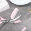 Pinkes Plastik-Augenbrauen-Trim-Set mit Metallbürste auf grauer Oberfläche