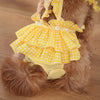 A yellow and white polka dot ruffled dog diaper for a small breed.