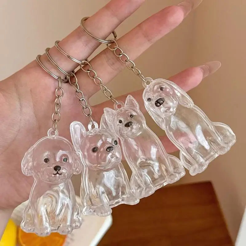 Clear resin dog hair storage keychain pendants shaped like small dogs being held by a hand