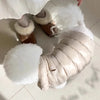 Flauschige weiße warme Winterjacke für Hund oder Katze, gezeigt mit passenden Wildlederstiefeln.