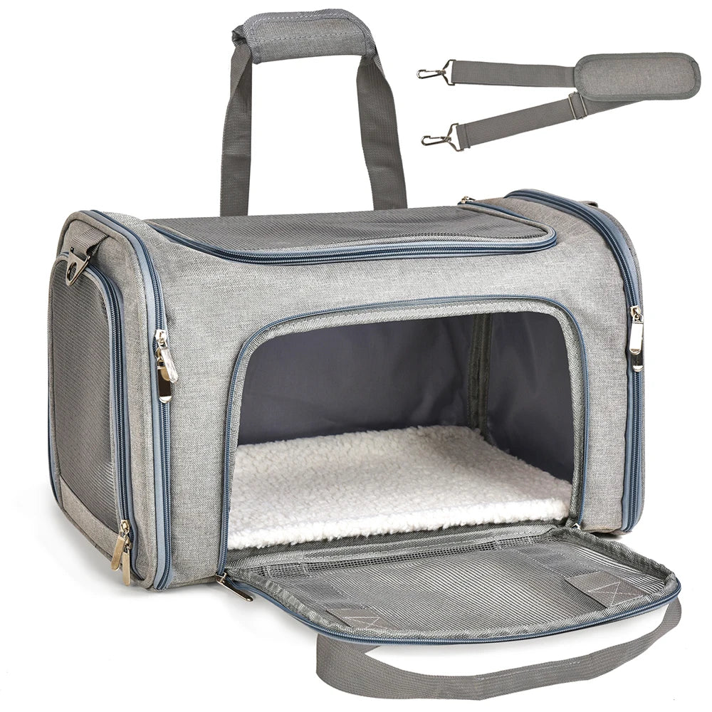 A gray travel pet carrier bag with a mesh floor and a handle, shown open.