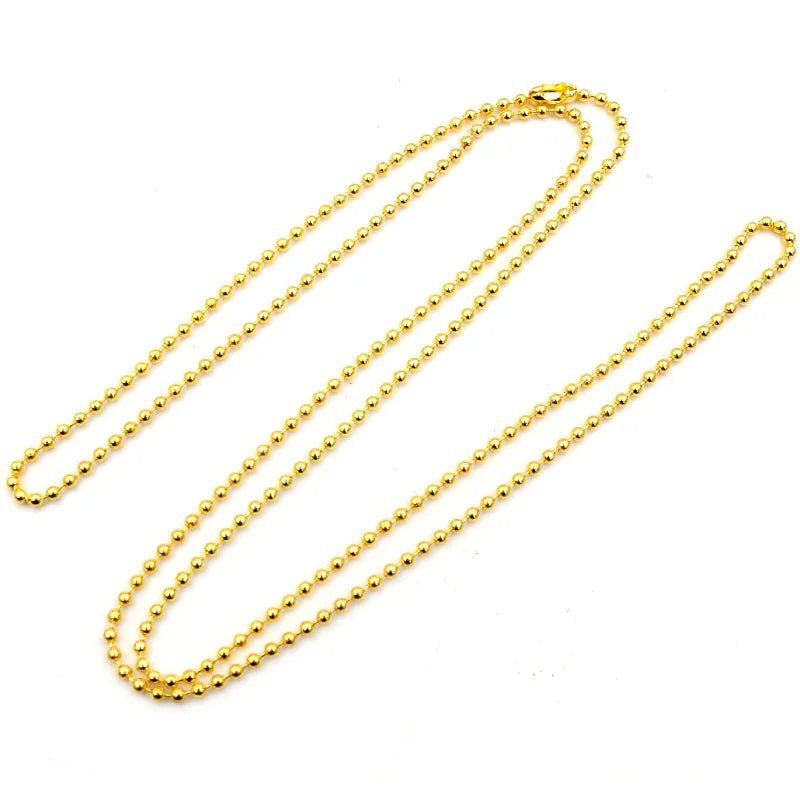 A set of thin gold-colored ball bead necklaces laid out on a white background.