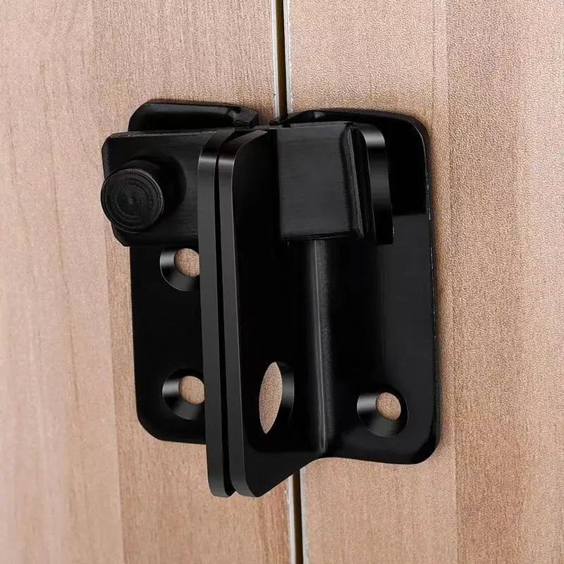 A black sliding bolt lock installed on a light wood door, used for home security.