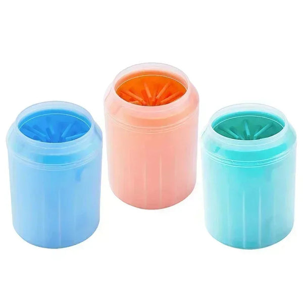Three silicone dog paw washer cups in blue, pink, and teal with orange cleaning bristles.