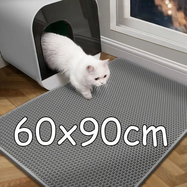 A white cat is standing on a gray honeycomb litter mat placed in front of a white pet enclosure.