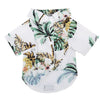 White short-sleeved shirt with a tropical leaf print featuring green, yellow, and pink foliage.
