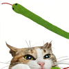 Eine Katze interagiert mit einem grünen Knisterspielzeug, das wie ein langer, flexibler grüner Schlauch aussieht.