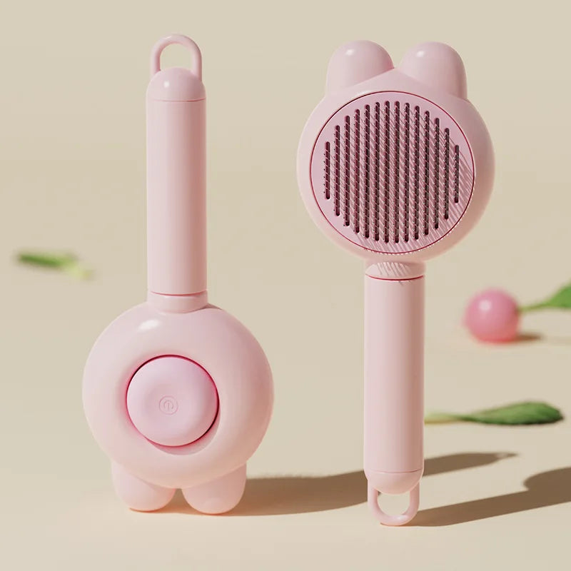 A pink pet deshedding brush for cats and dogs with a self-cleaning design shown in a studio setting.
