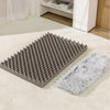 A gray orthopedic rectangular dog bed with a textured surface and a fluffy gray cover placed on a light carpet.