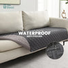 A gray waterproof pet mat is shown placed on a light-colored sofa, highlighting its anti-fouling features.