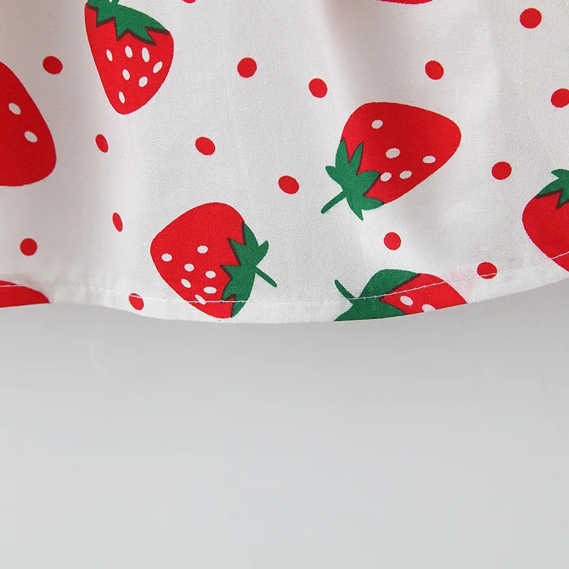 Weißes Stoffmuster mit roter Erdbeere-Druck, große Erdbeeren und kleine rote Polka Dots.
