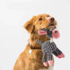 A golden retriever dog holding a pink and gray plush squeaky donkey toy.