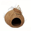 A natural coconut shell bird nest house with a straw-like entrance and a hanging lanyard.