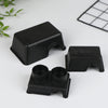 Black reptile and small animal hide boxes displayed on a white surface.