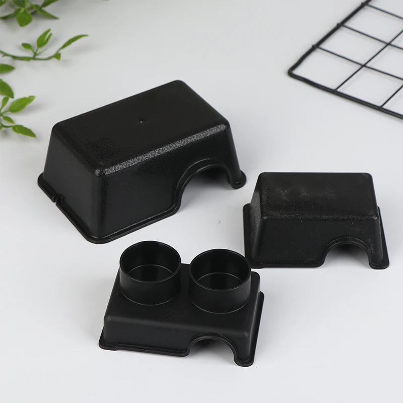 Black reptile and small animal hide boxes displayed on a white surface.