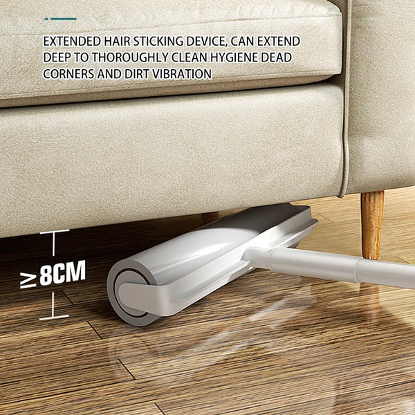 A silver extendable lint sticking device is shown cleaning a corner of a beige sofa fabric on a wooden floor.