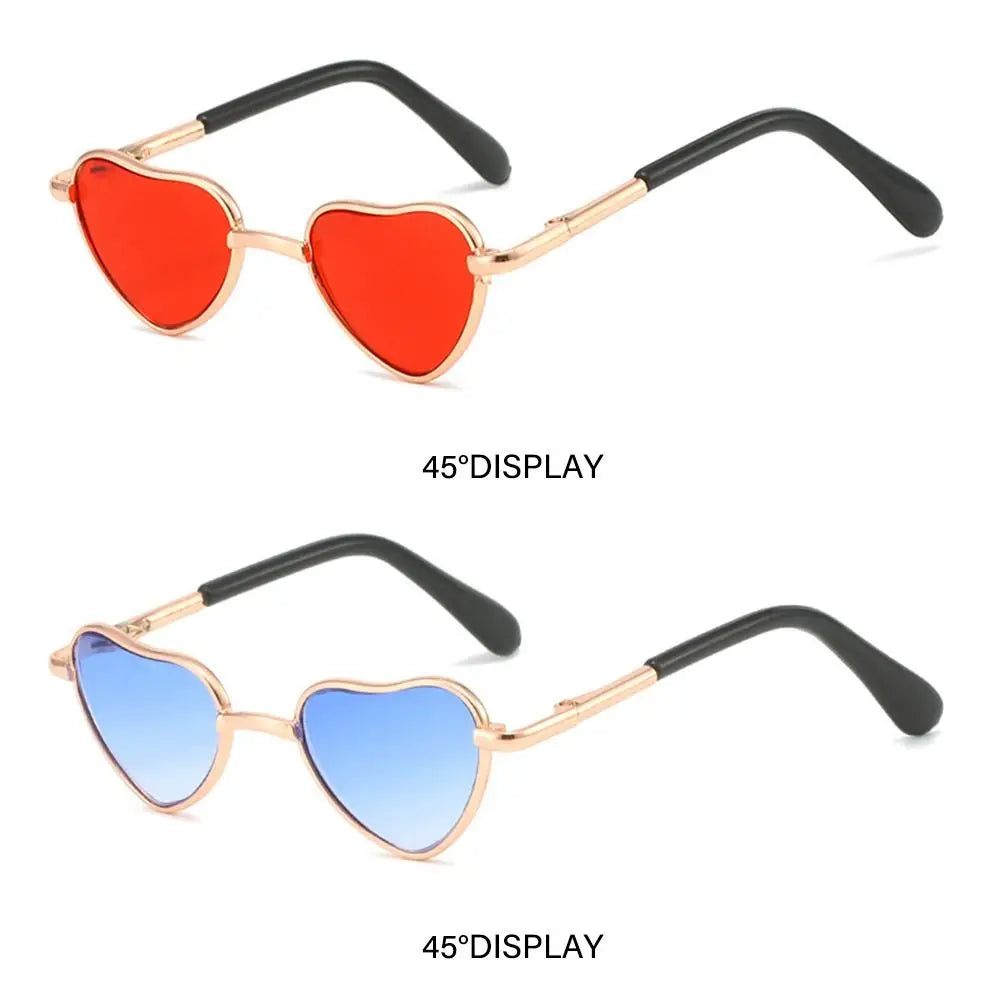 Pair of heart-shaped pet sunglasses, one red and one blue, with gold-toned frames.