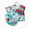 A white shirt with a vibrant blue tropical print featuring red hibiscus flowers and green palm leaves.