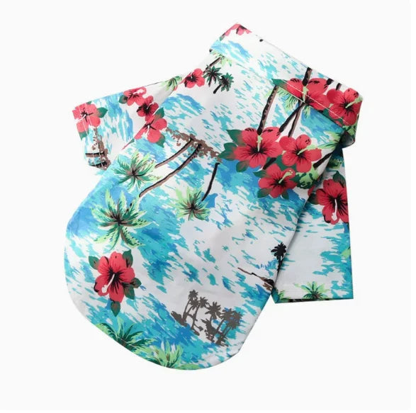 A white shirt with a vibrant blue tropical print featuring red hibiscus flowers and green palm leaves.