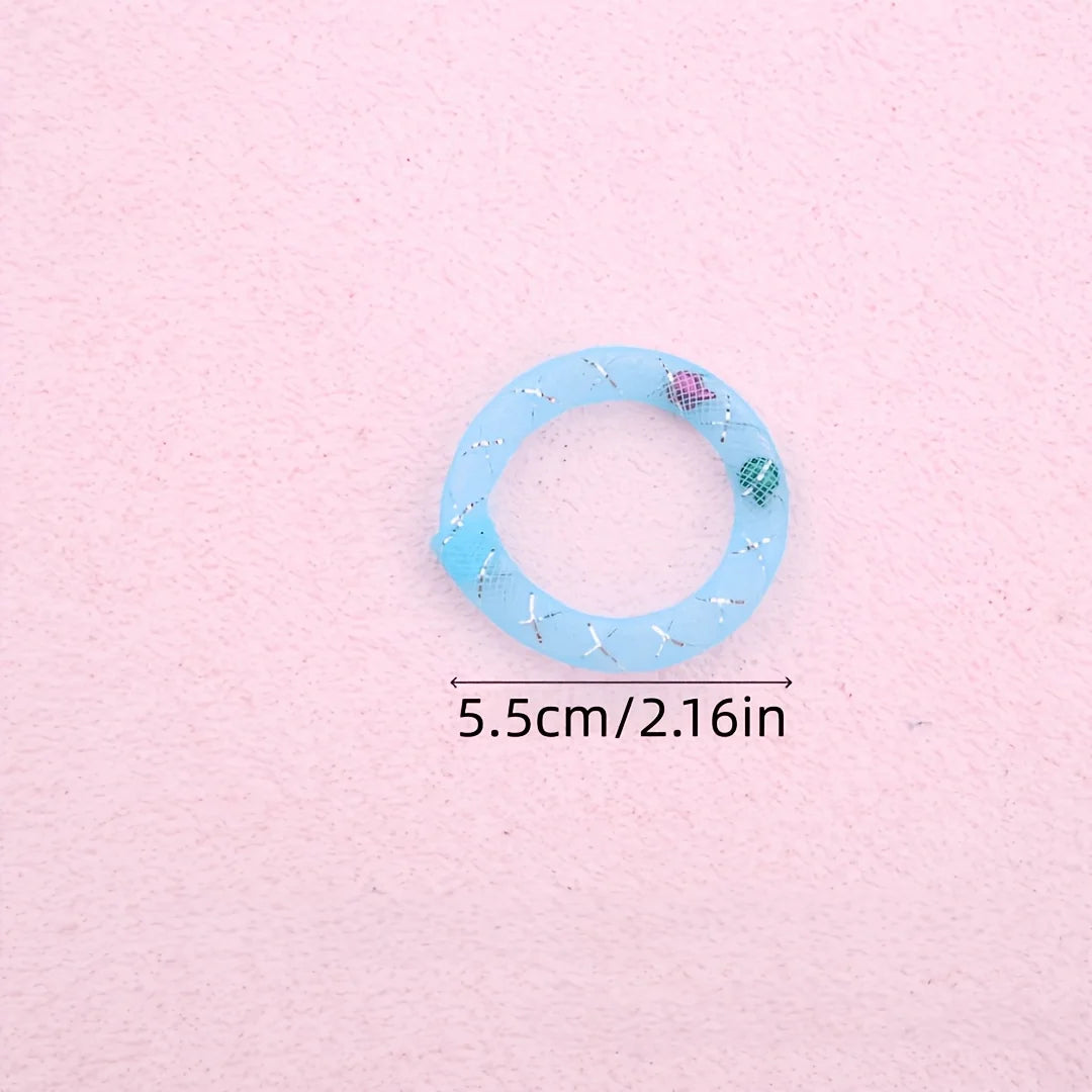 A light blue mesh donut chew toy with a bell, shown against a pink background.