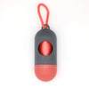 A capsule-shaped dog poop bag dispenser with a gray body and red base, attached to an orange carabiner clip.