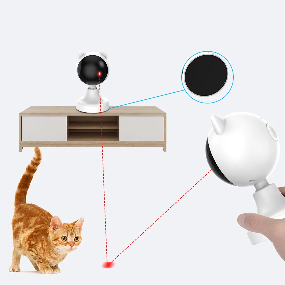 A cat is interacting with an automatic laser toy system that projects a red dot onto the surface.