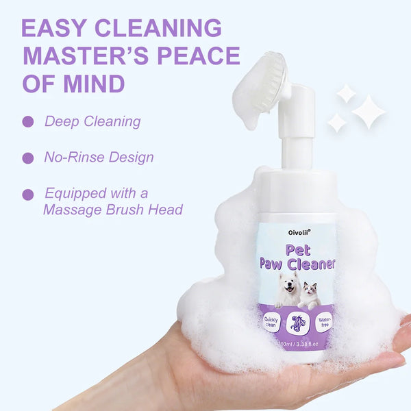 A hand holds a bottle of Pet Paw Cleaner with a brush head immersed in white foam, demonstrating easy cleaning.