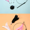 A black suction cup wand with a pink feather toy and a black handle on a light blue background.