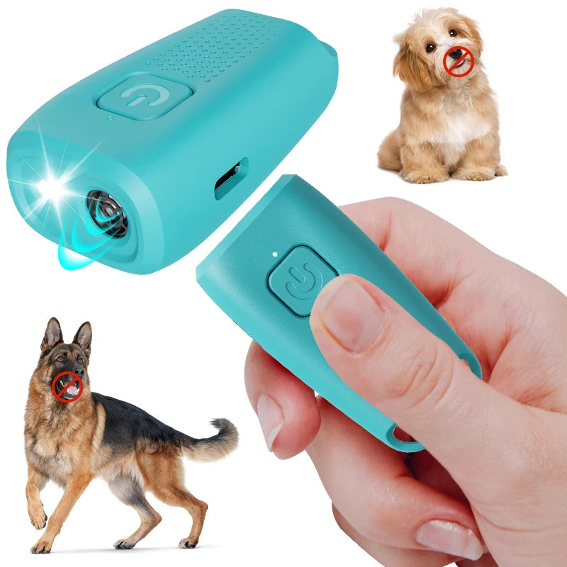 A hand holds a blue ultrasonic dog bark deterrent device next to a small dog and a puppy.