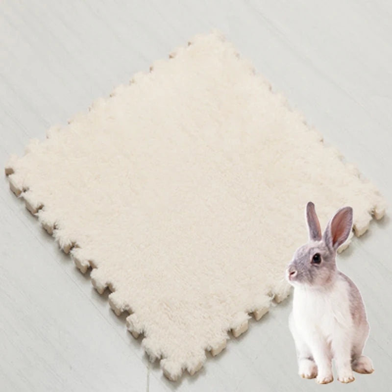 A small gray rabbit sitting on a beige fleece pet warming mat.