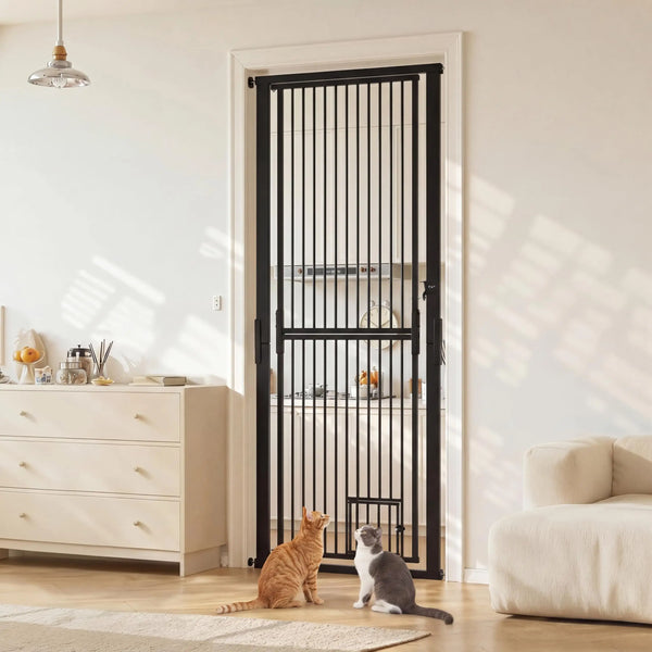 A tall black pet gate with vertical bars is installed in a white door frame, shown next to a light wood dresser and a beige s