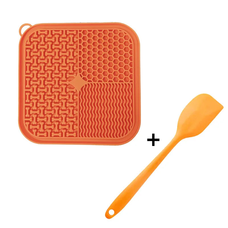 Orange silicone licking mat for dogs and cats with suction cups and an orange silicone spoon