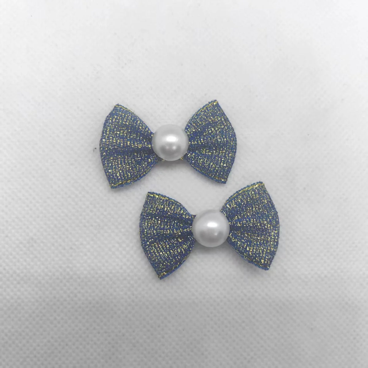 Ein Satz aus zwei glitzernden blauen Welpen-Bow-Knoten mit Perlenakzenten für das Tierpflegegrooming.