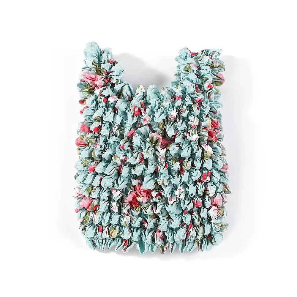 A reusable foldable bubble shopping bag made of ruffled fabric in shades of teal, pink, and green.