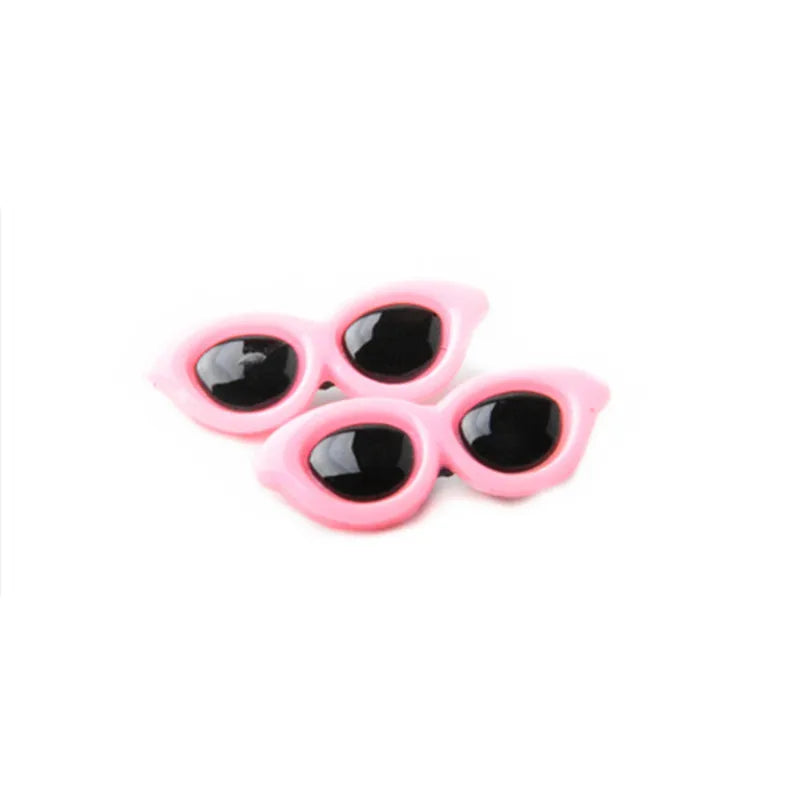A pair of pink pet hair clips for dogs and cats with black accents.
