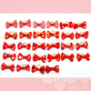 A collection of red and white pet hair bows with gentle rubber bands in various patterns.