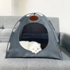 A gray foldable pet tent for cats is placed on a sofa, showing the interior where a white cat is resting.