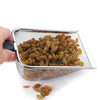 A hand holds a stainless steel pet poop shovel for terrariums filled with dried fruit.