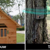 A dog house with a camera and a tree with a hanging deterrent device.