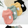A collection of knitted winter sweaters for dogs and cats in various colors including beige, black, green, and pink.