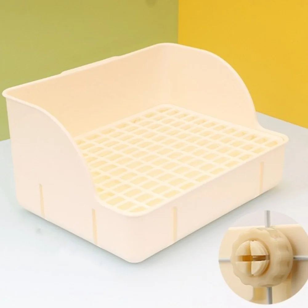 Una caja de litter detachable de color beige claro con rejilla para pequeños mamíferos, mostrada sobre una superficie blanca.