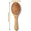A wooden bamboo hair brush with massage bristles shown vertically, measuring 25cm long.