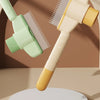 A light green and yellow self-cleaning pet brush with massage pins is shown angled against a brown background.