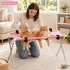 Una mujer está usando una hamaca plegable para cepillar las uñas de un gato naranja.