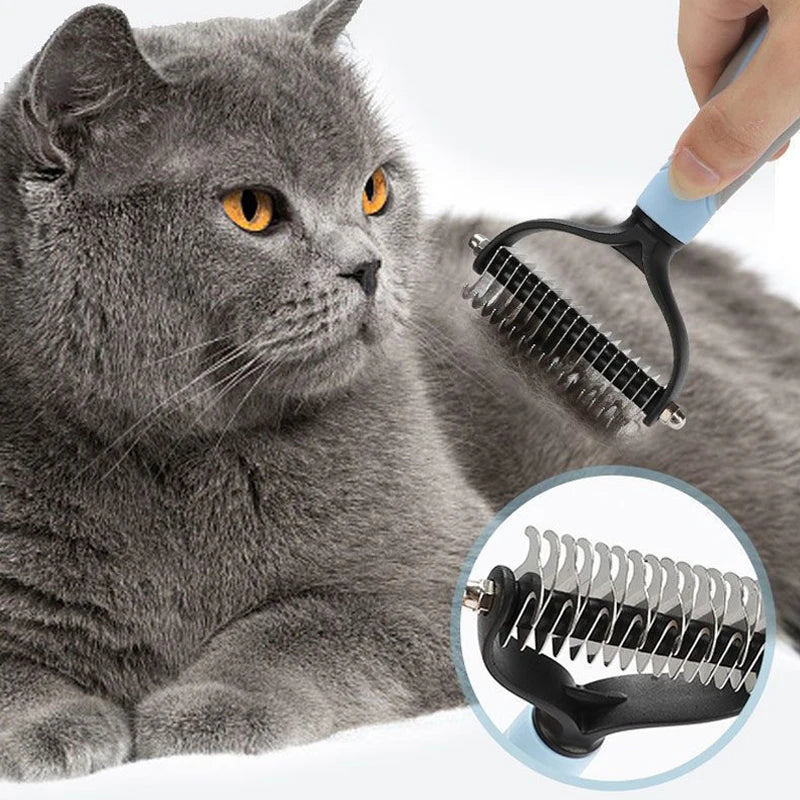 A hand is using a black pet deshedding brush on the fur of a gray cat.