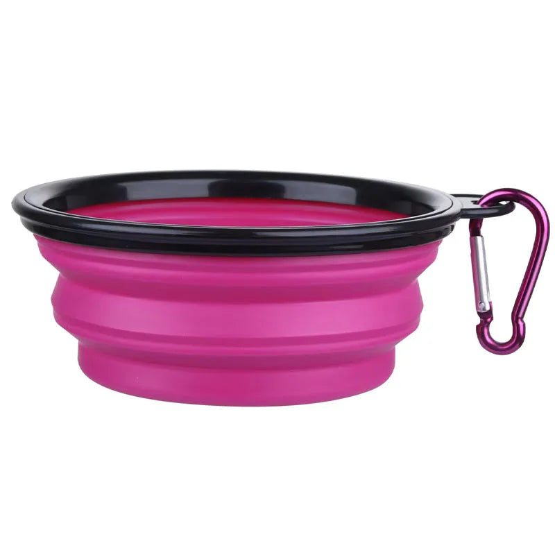 A bright pink silicone pet feeder bowl with a black rim and a carabiner clip.